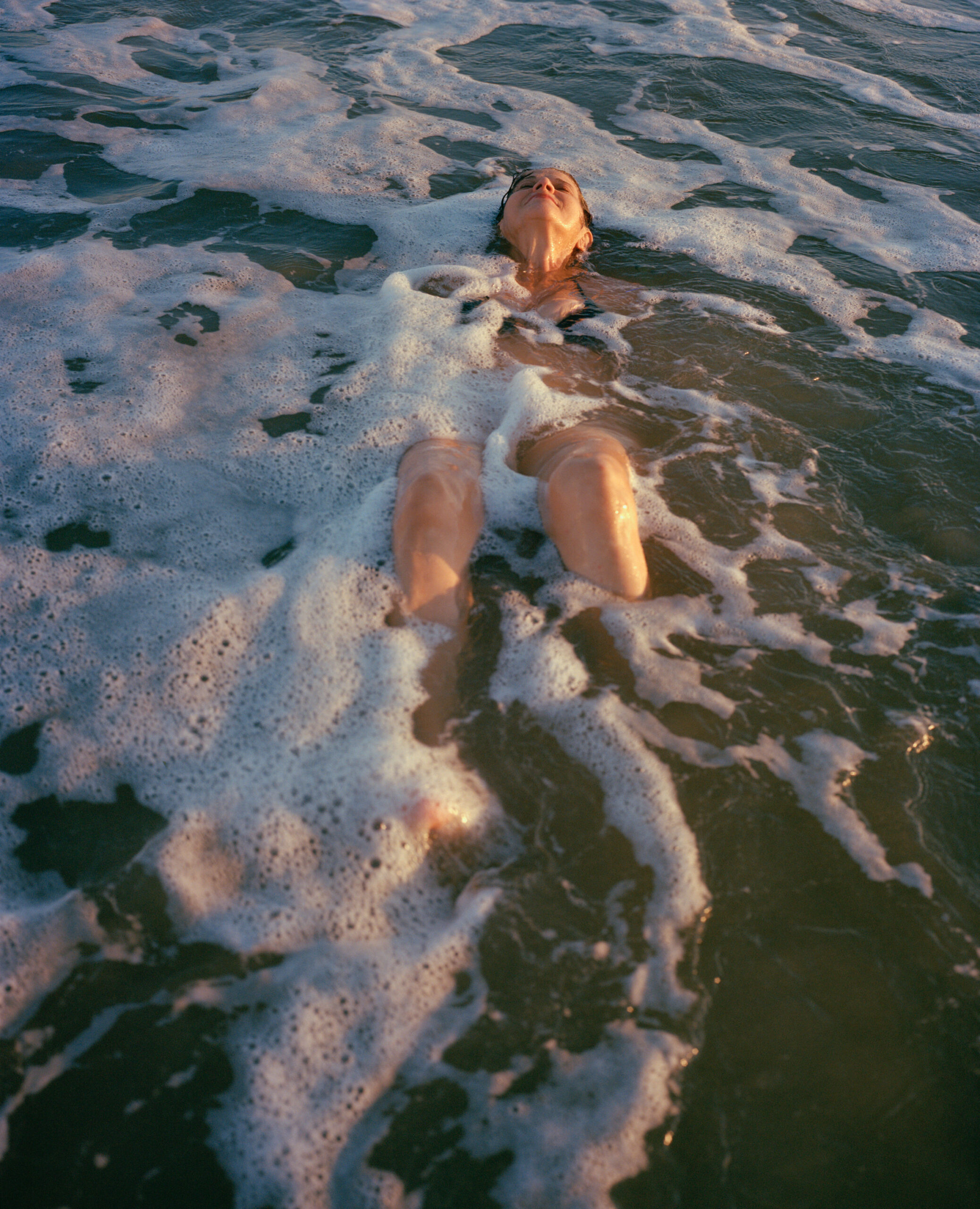 Woman laying in the water at the beach