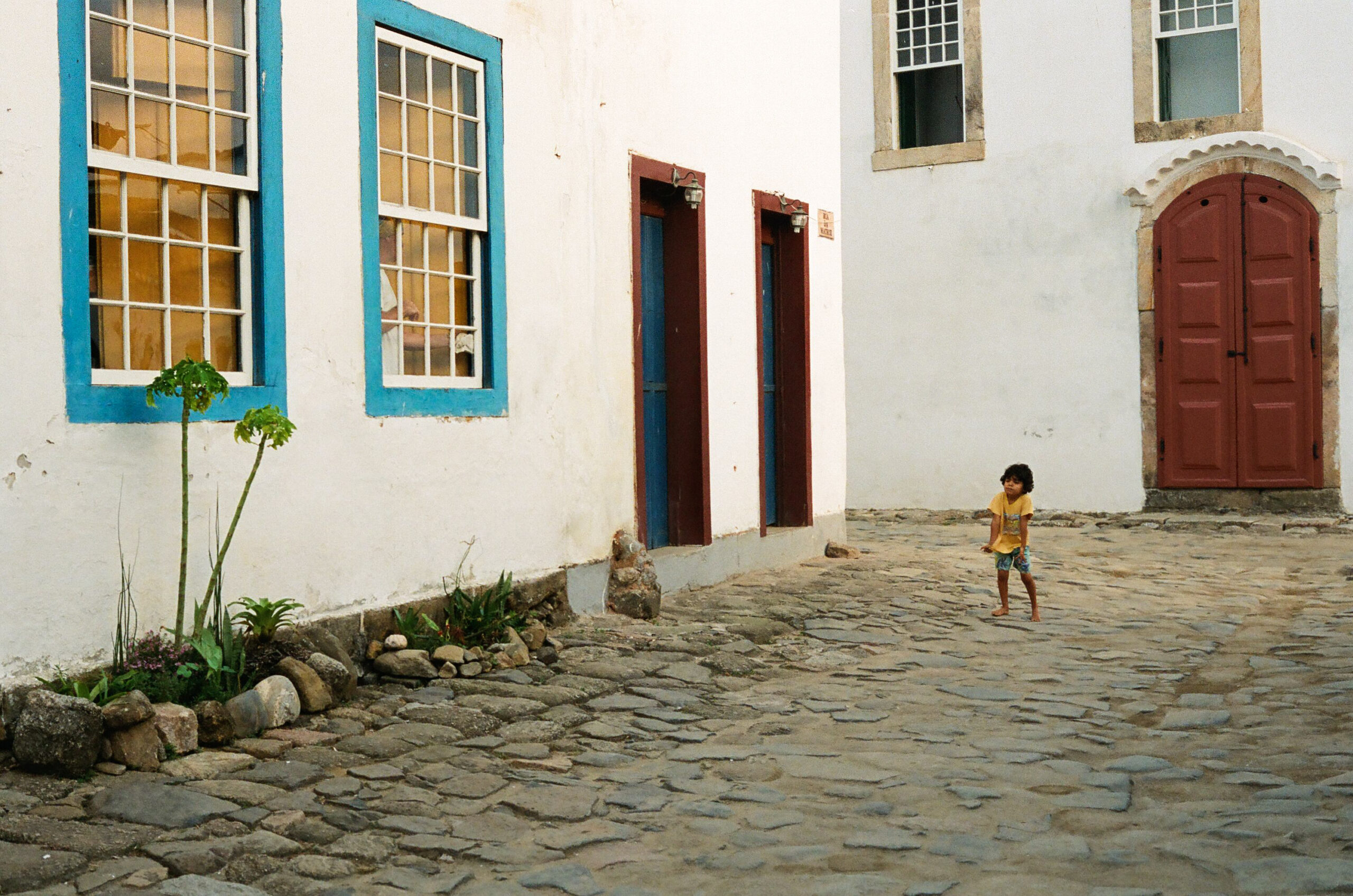 Child standing in cobblestone street