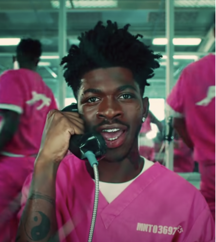 American rapper Lil Nas X in pink prison outfit talking on the telephone